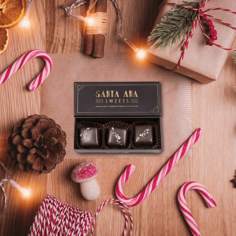 picture of Santa Ana Sweets 3-piece box of chocolate covered salted caramels, surrounded by holiday decorations