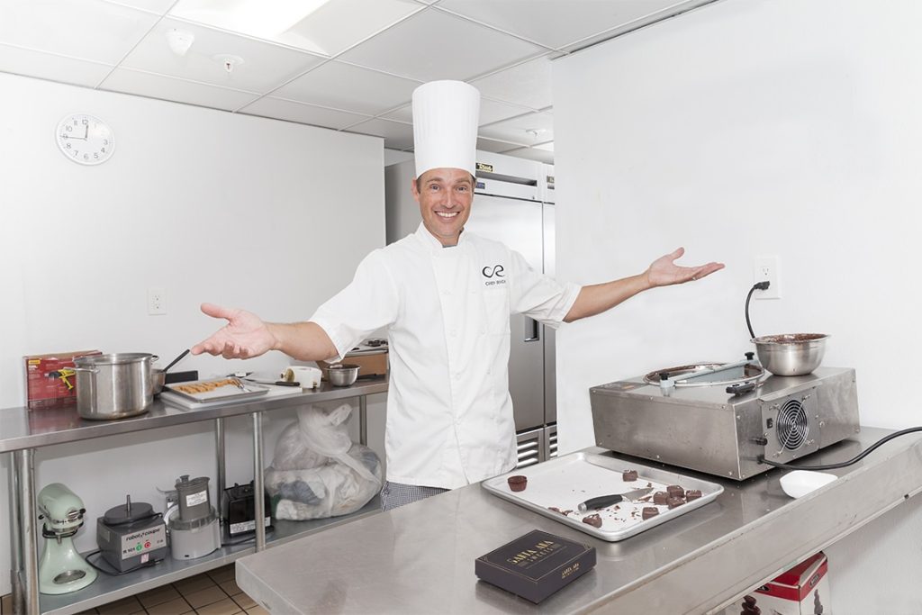 Chef Rick Proudly displaying his gourmet chocolate covered salted caramels in his kitchen